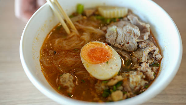 Authentic Thai Pork Noodle Bowl with Fresh Herbs and Boiled Egg