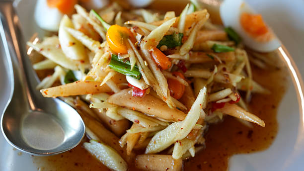 Authentic Som Tum Thai with Boiled Egg Presented on a Clean White Plate