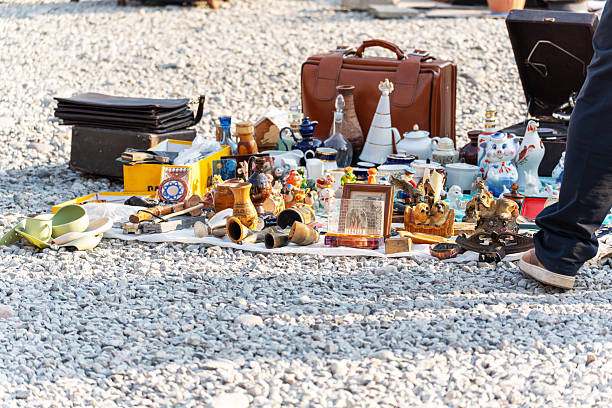 Bishkek, Kyrgyzstan - November 30, 2025: A collection of vintage items, ceramics, and miscellaneous objects displayed for sale at a flea market on a sunny day.