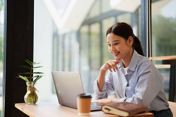 istock Young woman smiling using laptop computer in cafe 2249188710