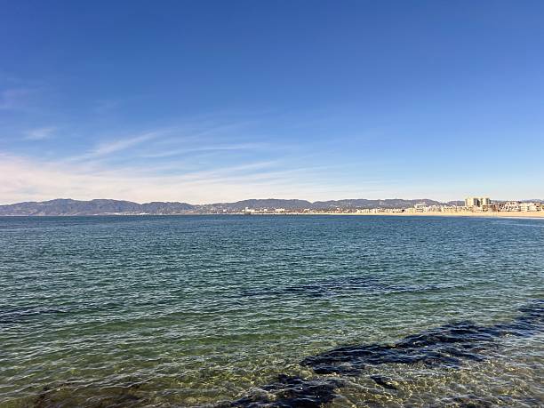 istock Vibrant Coastal View With Clear Waters and Distant Mountains Under a Bright Blue Sky in a Tranquil Setting 2249189039