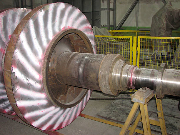 istock Large industrial turbine rotor, highlighted with red markings, streaks. The metallic component with curved vanes rests on supports in workshop environment with yellow safety barriers. Turbocharger rotor 2249189449