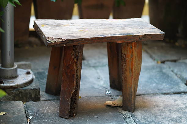 This rustic wooden stool adds charm to any outdoor space. Its earthy tones and natural textures create a warm, inviting atmosphere perfect for relaxation.