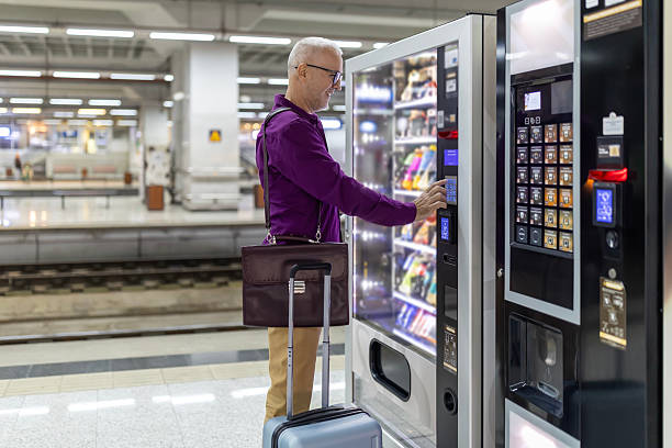 istock Senior adult choosing snack from vending machine at train station 2249194770