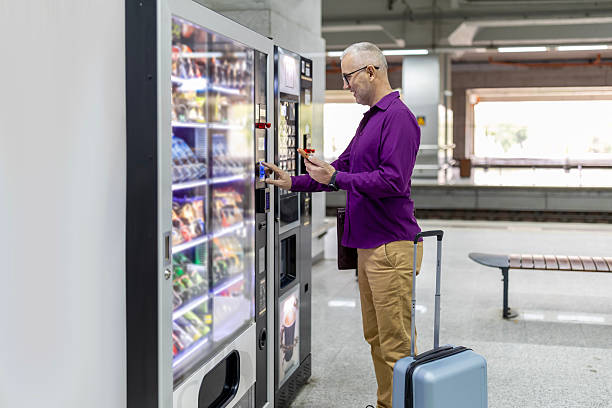 istock Mature adult man purchasing snack from vending machine 2249194774