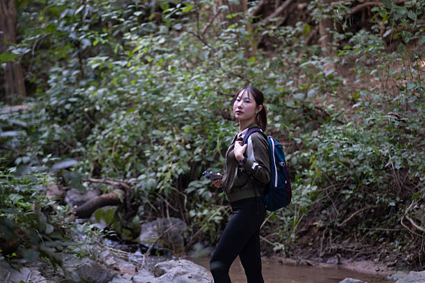 istock A woman is walking through a forest with a backpack on her back 2249196272