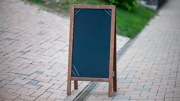 istock Blank wooden chalkboard stand placed on sidewalk 2249198098