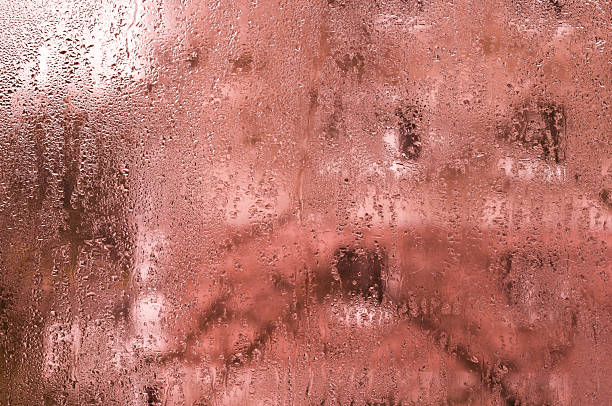 abstract background of purple wet glass. window covered with tiny water droplets. humidity forms natural pattern on transparent surface. backdrop with natural pattern texture of wet glass. water drops
