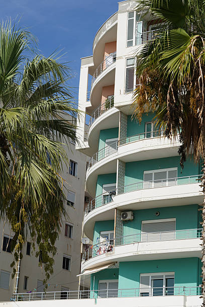 istock Uniform facades with large windows create a bright housing line above an Albanian road. This residential area fits rental markets, relocation plans, agency portfolios, and property purchase searches. 2249201790