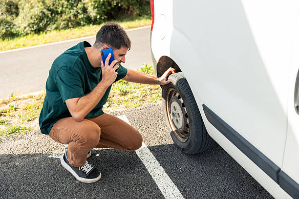 istock Frustrated man calling for help with flat tire on road 2249202387