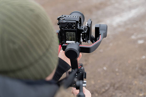 istock Professional filming setup with a mirrorless camera on a gimbal stabilizer held by an operator capturing stabilized shots in cold outdoor conditions 2249205420