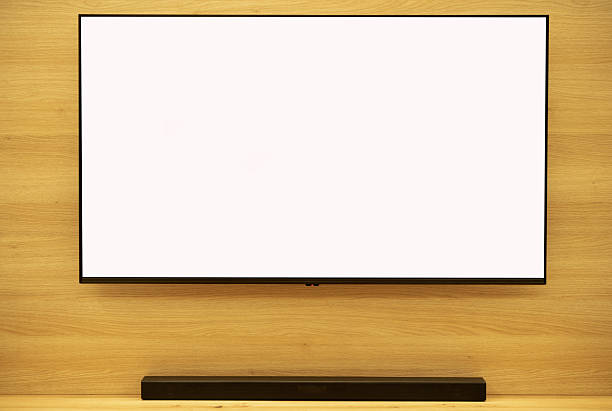 istock White, empty, blank smart TV screen with space for adding logo or advertisement. Mockup,  living advertisement. Oak wall and soundbar stand in the background 2249206059