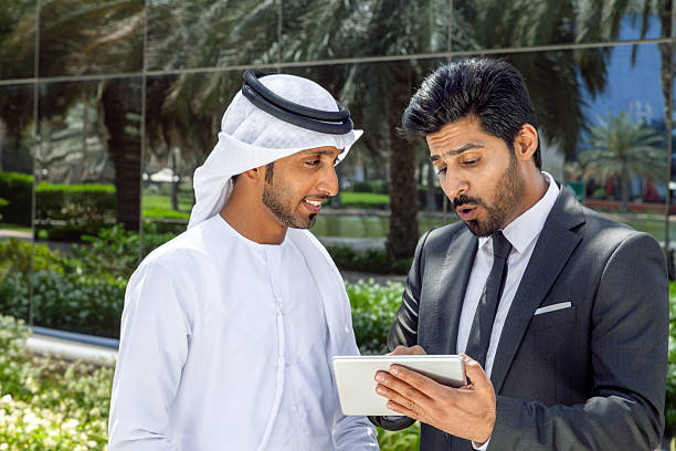 istock Middle Eastern Businessmen Discussing Project on Digital Tablet Outdoors in Dubai, United Arab Emirates 2249206162