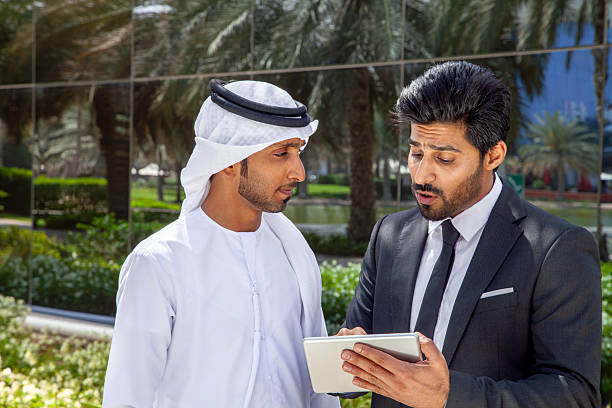 istock Middle Eastern Businessmen Discussing Project on Digital Tablet Outdoors in Dubai, United Arab Emirates 2249207489