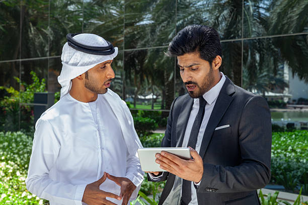 istock Middle Eastern Businessmen Discussing Project on Digital Tablet Outdoors in Dubai, United Arab Emirates 2249207490