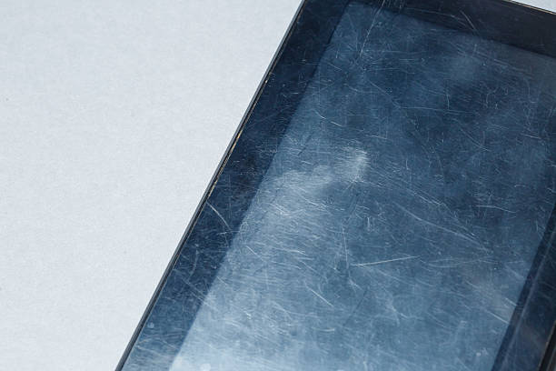 istock Black scratched tablet with a protective film on a gray background. Protect your device screen 2249211896