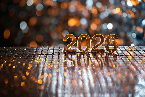 istock Golden 2026 Numbers on Reflective Surface with Sparkling Holiday Lights 2249216599