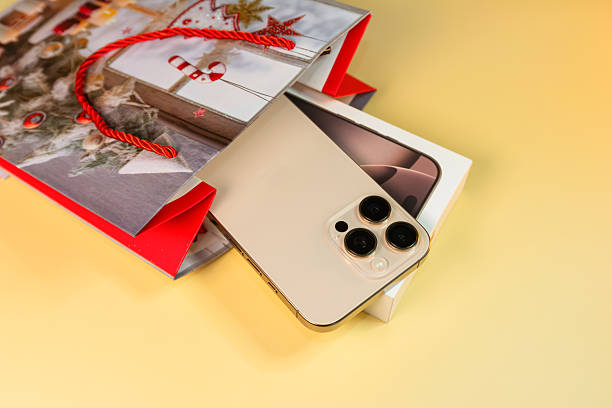 Krakow, Poland - November 6, 2025. The latest Apple iPhone 17 Pro Max in Cosmic Orange, standing upright with its vivid display active beside the matching color box. The image emphasizes Apple’s innovative design, premium packaging, and the excitement surrounding the launch of this signature smartphone for 2025.