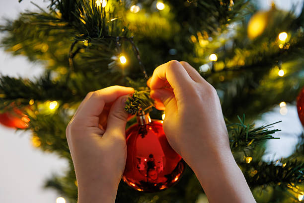 istock Child hanging red Christmas ornament 2249218331