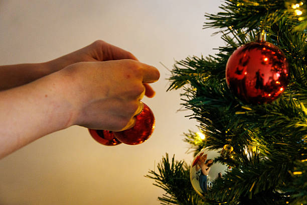istock Hands decorating Christmas tree with festive ornaments 2249218915
