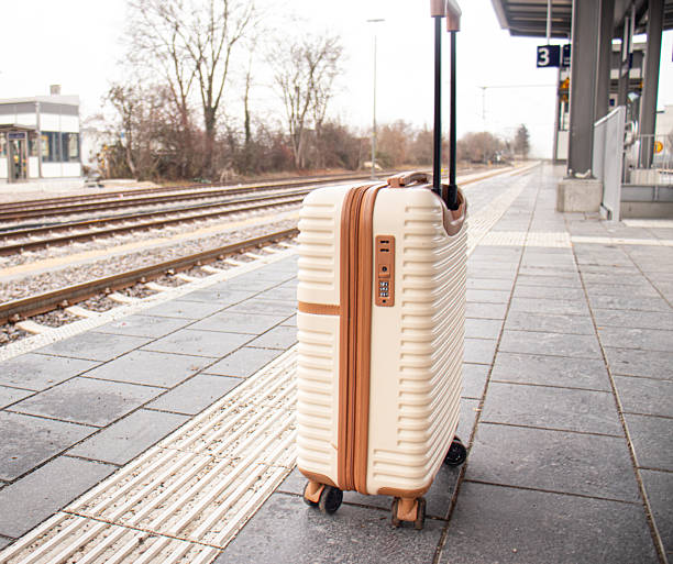 istock Travel suitcase standing on a train station platform beside railway tracks 2249219008