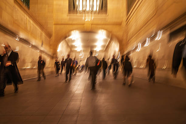 Crowds of people navigate the galleries of Grand Central Terminal in New York City during the evening rush hour, creating a lively atmosphere.
