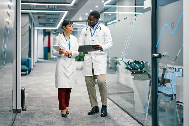 istock Diverse medical professionals walking communicating in modern hospital corridor 2249223221