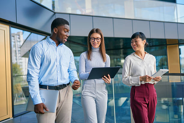 istock Diverse business team discussing work walking outside office building 2249223414