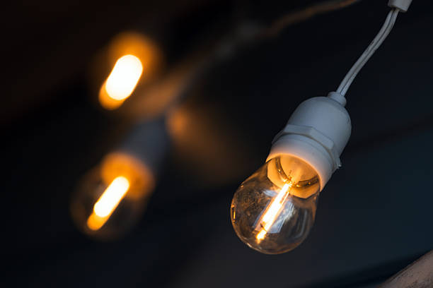 istock Soft warm Edison bulbs hang in a dark space 2249225058