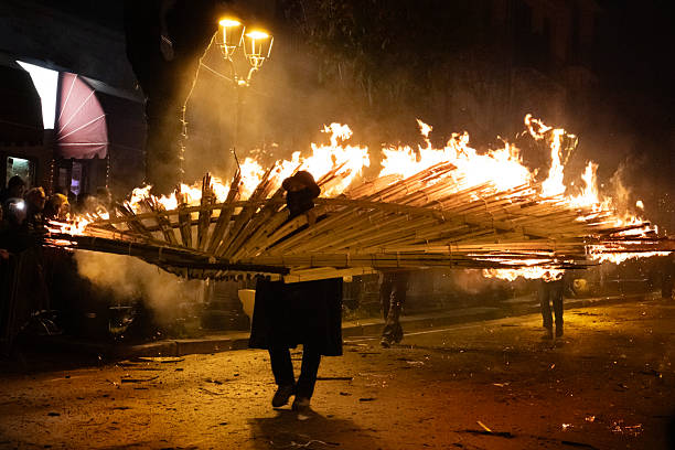 Agnone, Molise (Italy): men in traditional black cloaks and hats carry flaming torches during the ancient Christmas event called 'Ndocciata, celebrated in Agnone, city in the Molise region of Southern Italy. In this religious celebration, a great number of “‘ndocce” (torches) are carried in a typical fan shape along the main town road. The carriers start with only one torch, then bring each up to 24 fires, each about four metres high. The celebration ends with a bonfire in the town square.