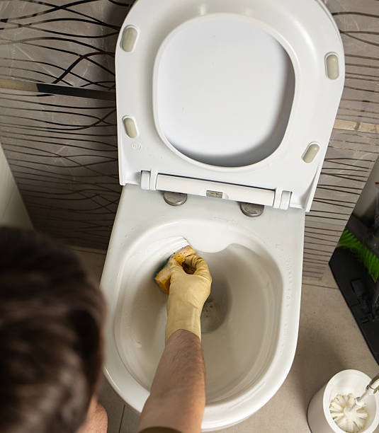 istock person cleaning a toilet bowl 2249228289
