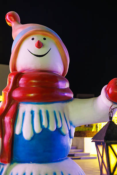 istock Colorful snowman statue holding lantern at night 2249232135