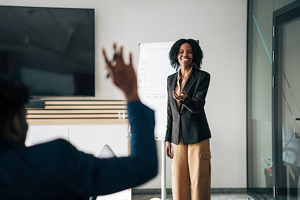 istock Businesswoman answering question during corporate presentation 2249232398