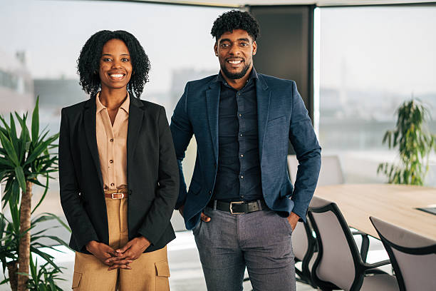 istock Business partners smiling in modern office working together 2249232643
