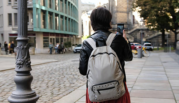 istock Beautiful Woman With Backpack Strolls On Street 2249233228