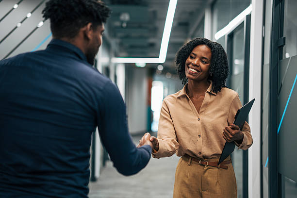 istock Business professionals shaking hands in modern office hallway 2249234255