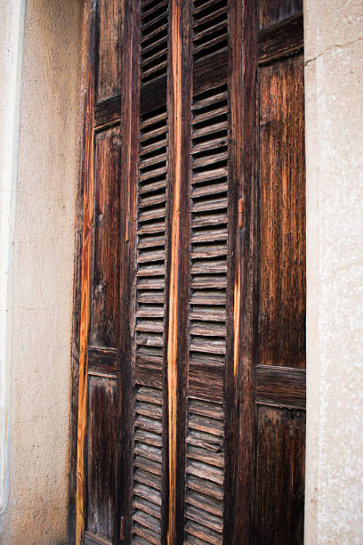 istock Weathered Wooden Shutters with Rustic Texture and Golden Grain Detail 2249237225