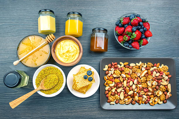 Delightful spread of healthy snacks featuring fruits, nuts, and honey on a wooden table