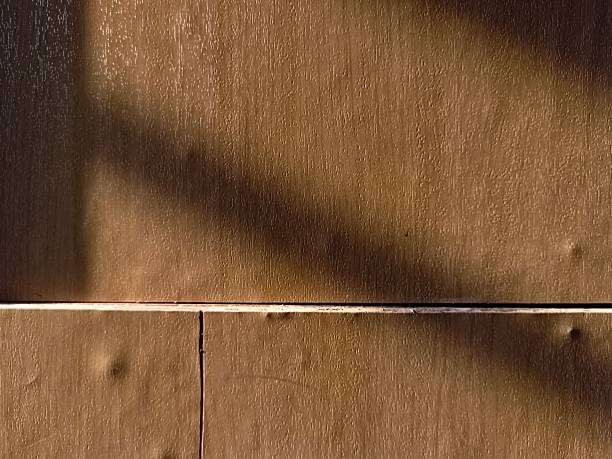 Wooden cabinet surface with horizontal panel lines and soft warm lighting.