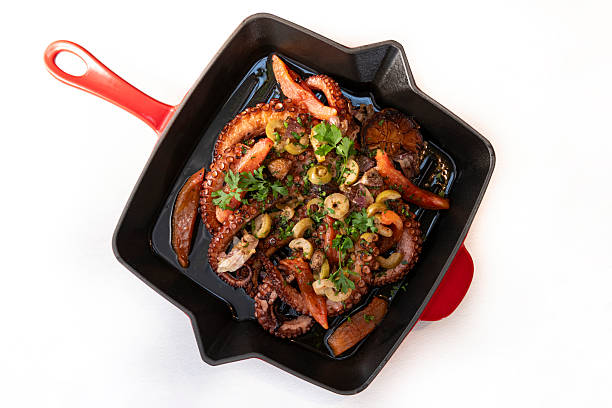 Grilled octopus with garnish served on a cast iron skillet