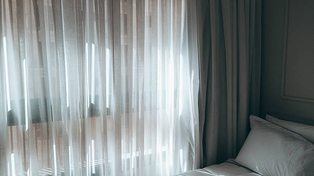 istock Serene Cozy Bedroom with Fabric Curtains and Warm Natural Light 2249247710