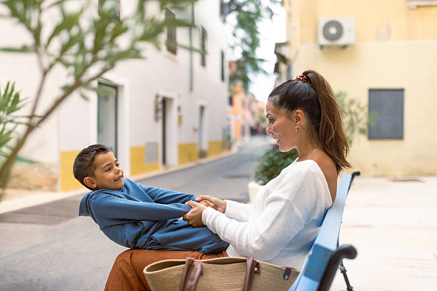 istock Mother and son enjoying time on a bench in a quaint alley 2249249530