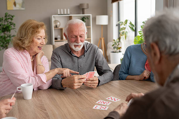 istock Seniors laughing and socializing over card game 2249249696