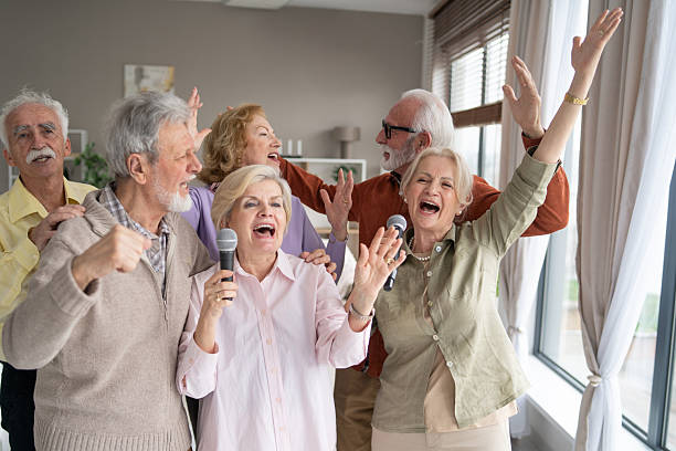 istock Elderly people joyfully singing at a home karaoke night 2249249720