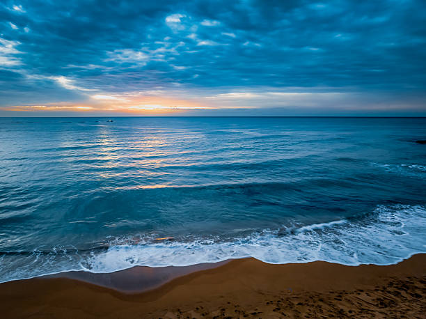 Sunrise Seascape with rain clouds at Bilgola Beach on the Northern Beaches of Sydney, NSW, Australia.