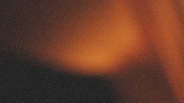 istock light orange on black backdrop for wallpaper design, in a grain texture bright color glow 2249260538