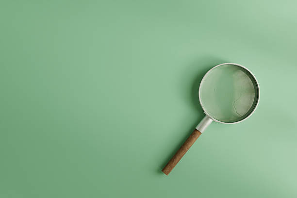 istock A magnifying glass with a wooden handle placed on a clean mint green background- 3D rendering 2249263148