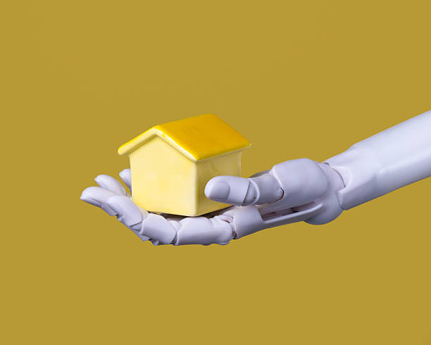 istock Smart Home Automation: Robotic Hand Presenting a House Concept on Gold Background 2249264056