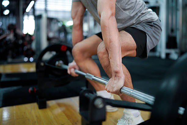 istock muscular body builder sport man is practice weight training on squat barbell for core muscle inside gym with dark background for exercising and workout usage 2249265333