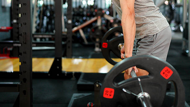 istock muscular body builder sport man is practice weight training on squat barbell for core muscle inside gym with dark background for exercising and workout usage 2249265336